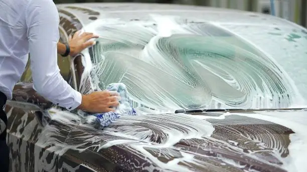 Expensive carwash, busy male washing elite car with cleaning foam, business, stock footage